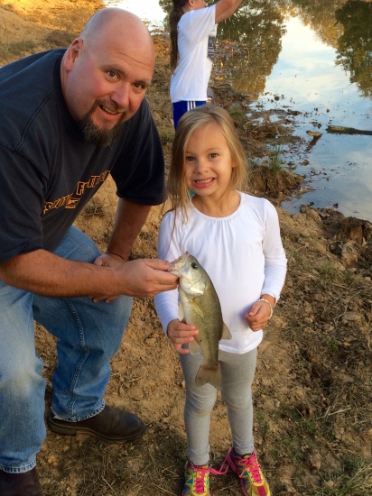 Kiser Federico shows off her first ever bass. It was so big she had to help her Uncle Mike lift it up for the picture.
