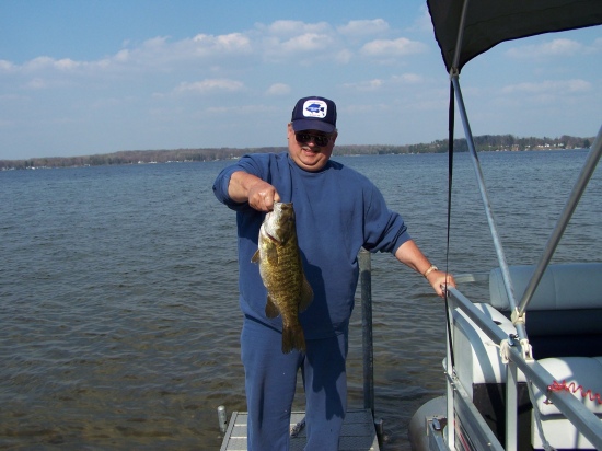 This smallmouth was caught on a crankbait on Chippewa Lake in mid Michigan that is more known for its pan fish.  It was caught and measured but not weighed, but it qualified for a Michigan Angler award due to its length which was 28 inchs and then released under my dock.  A previous angler award is on my hat in the picture.... that was for a bowfin (dogfish) also caught in Chippewa Lake.